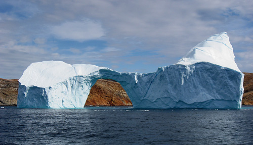 Water in three states: liquid, solid (ice), and (invisible) water vapor in the air.: Clouds are accumulations of water droplets, condensed from vapor-saturated air. Iceberg between Langø and Sanderson Hope, south of Upernavik, Greenland. Photograph by Kim Hansen courtesy of Wikipedia.